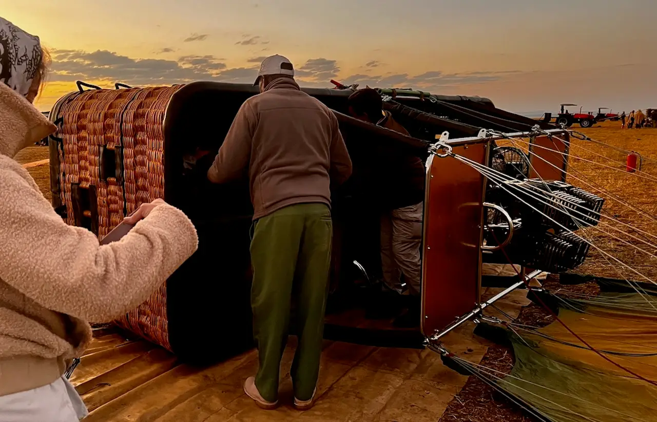 Picture of my sister shooting the balloon on the ground in Kenya: Climbing into the balloon sideways - Ultimate Maasai Mara Hot Air Balloon Adventure - 1