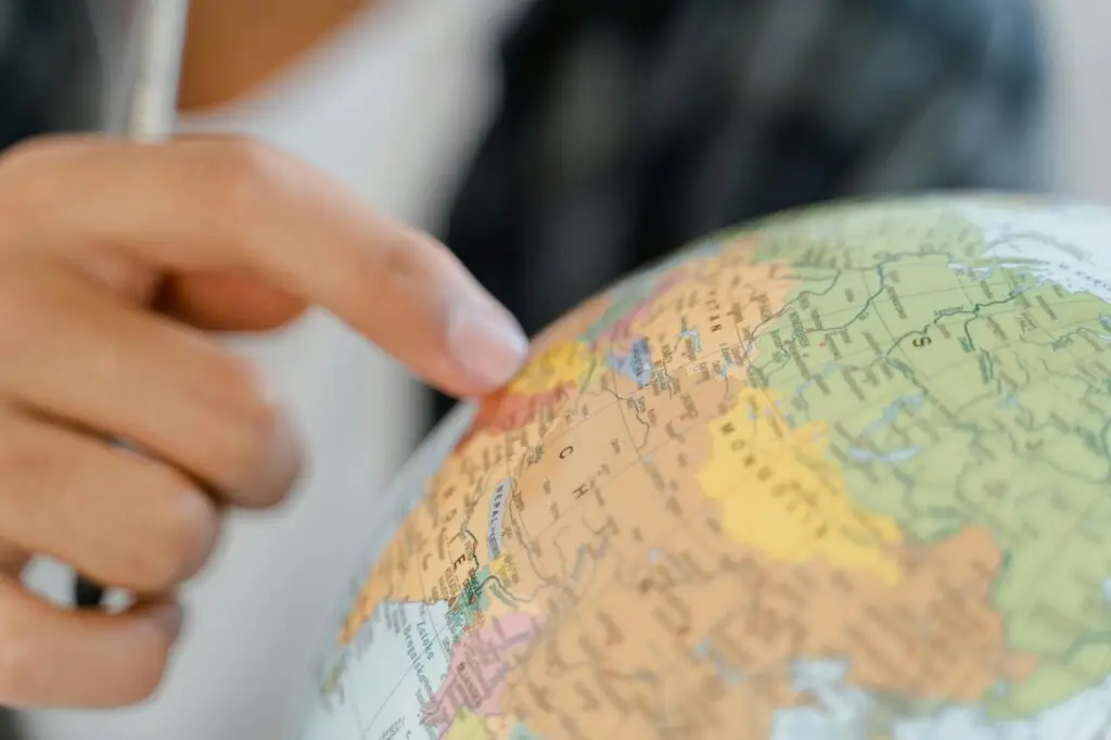 Picture of a finger on a globe.
