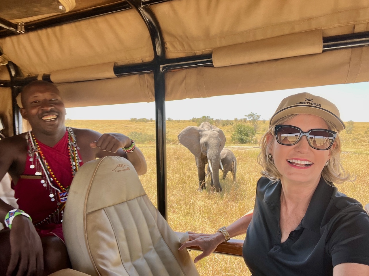 A picture of the author in a jeep with the guide in Kenya with elephants in the background