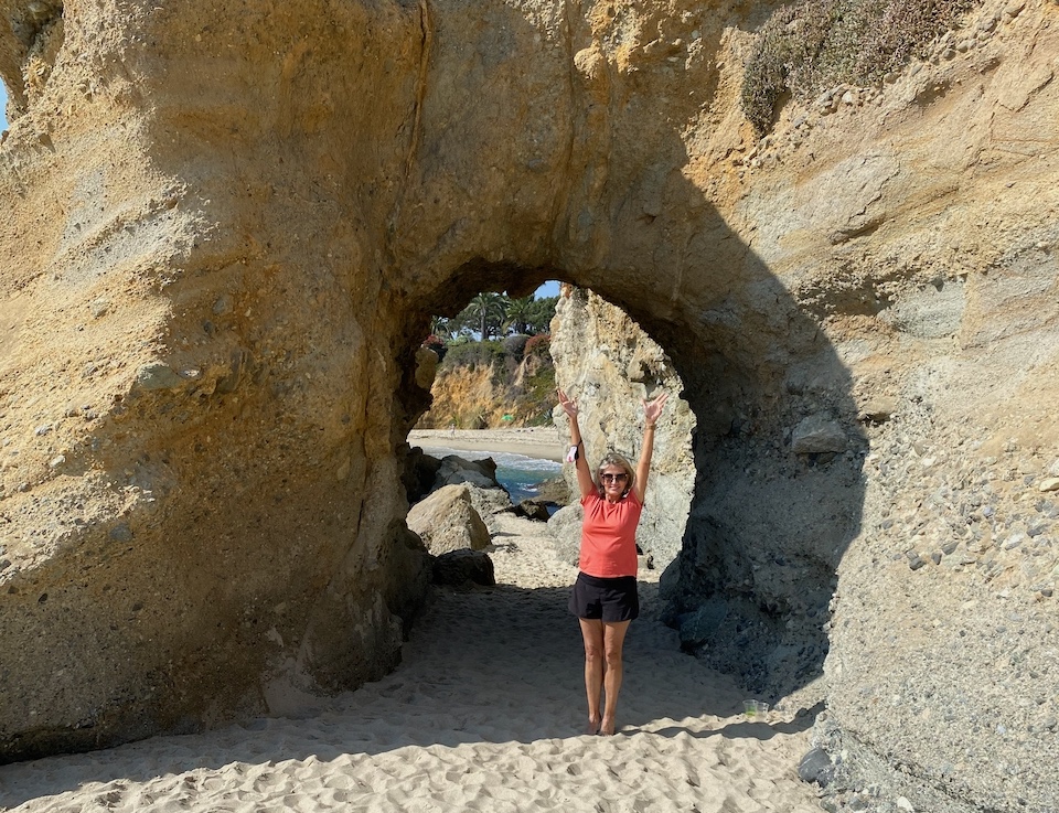 Jo-Anne standing in front of a cave hole in Laguna beach